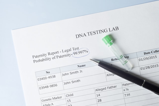 Paternity test results with pen and lab sample.