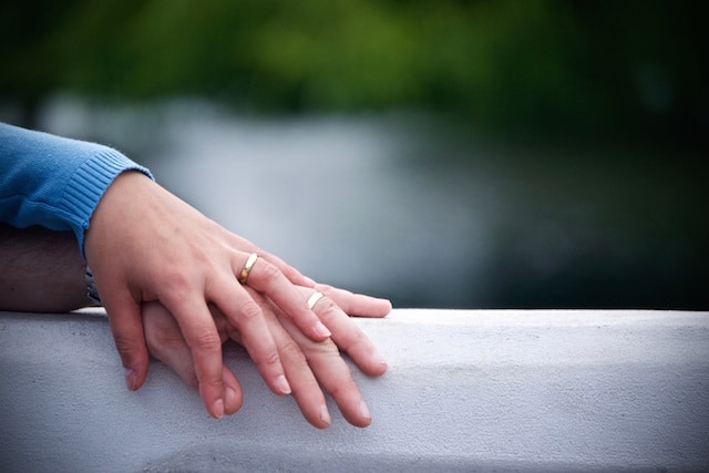 couple with hand rings holding each other